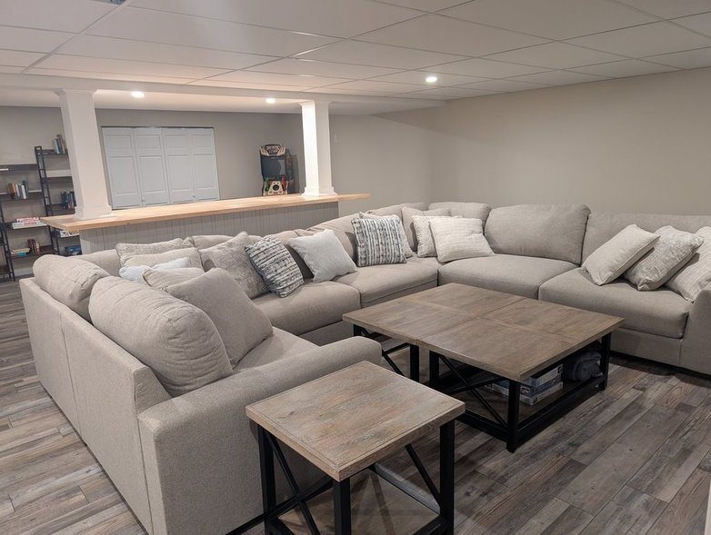 Lower-level family room with a big U-shaped sectional and coffee tables
