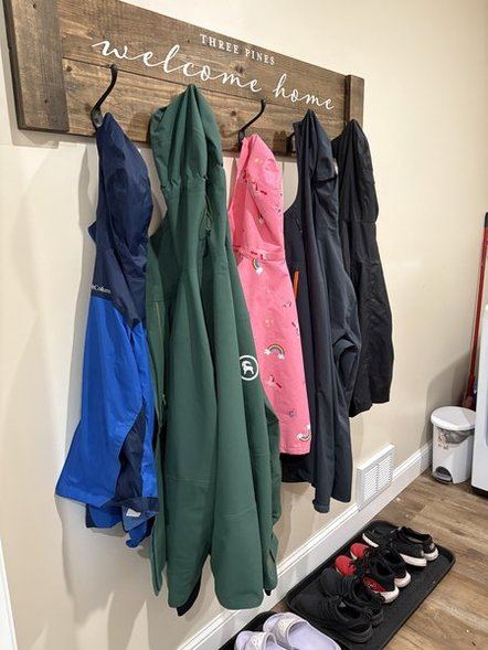 Three Pines welcome home coat-hook sign